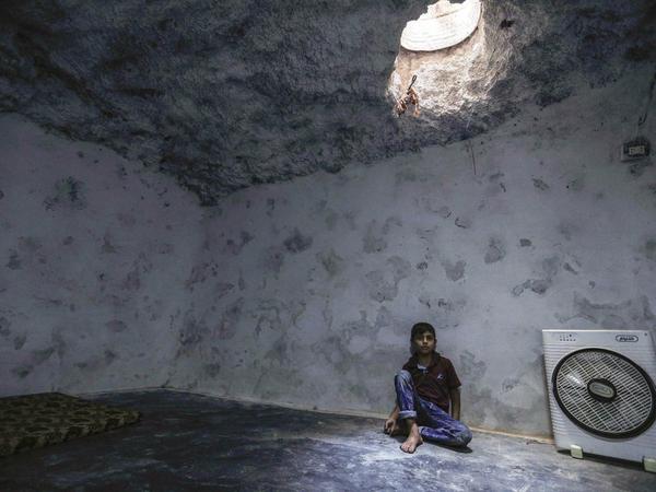 Ein syrischer Junge in einer Höhle, die seiner Familie Schutz bietet.