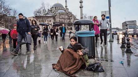 Ein syrisches Mädchen bettelt mit seinem kleinen Bruder in Istanbul.