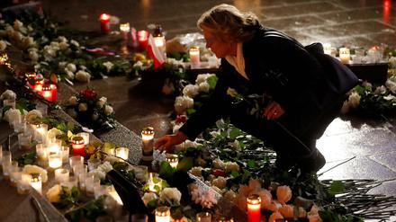 Gedenken. Eine Frau stellt auf dem Breitscheidplatz eine brennende Kerze auf.