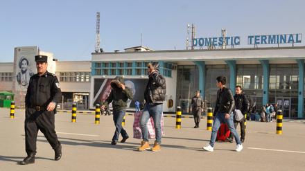 Eine Gruppe junger Männer verlässt am 23.02.2017 in Begleitung eines Polizisten das Flughafengebäude in Kabul, Afghanistan.
