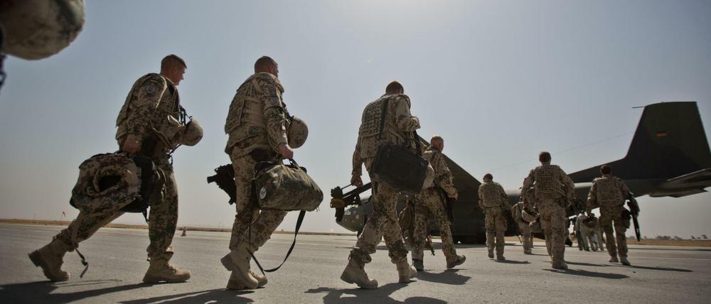 Bundeswehrsoldaten gehen auf dem Flughafen von Kundus in Afghanistan zu einer Transportmaschine vom Typ Transall C-160. 