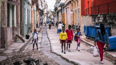 Kinder gehen durch die maroden Straßen der kubanischen Hauptstadt Havanna. (Kuba). 