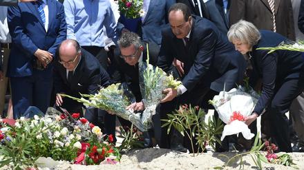 Bundesinnenminister Thomas de Maiziere (2.v.l.), der tunesische Innenminister Mohamed Najem Gharsalli (2.v.r.) und die britische Innenministerin Theresa May legten am Montag am Strand vor dem Imperial Marhaba Hotel in Sousse (Tunesien) Blumen nieder. 
