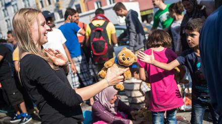 Eine freiwillige Helferin verteilt am Münchner Hauptbahnhof Stofftiere an Flüchtlingskinder.