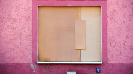 Ein Holzplatte ist vor einem Fenster einer Asylbewerberunterkunft in Freital angebracht. Bei einem Anschlag auf eine Wohnung von Asylbewerbern ist in Freital ein Mensch leicht verletzt worden.