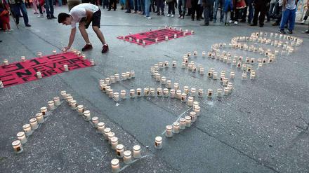 Ein Armenier stellt vor der türkischen Botschaft in Athen Kerzen auf - zum Gedenken an den Völkermord des Osmanischen Reichs an den Armeniern.