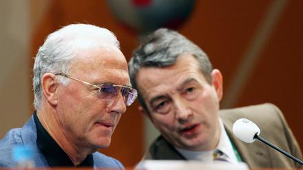 Der Präsident des deutschen FIFA Organisationskomitees, Franz Beckenbauer (l.), spricht am 07.12.2005 mit seinem Vize-Präsidenten, Wolfgang Niersbach, auf einer Pressekonferenz auf der Leipziger Messe. Beide informierten über den Stand der Vorbereitungen zur Endrundenauslosung der Fußball-Weltmeisterschaft 2006 am 09.12.2005 in Leipzig. 