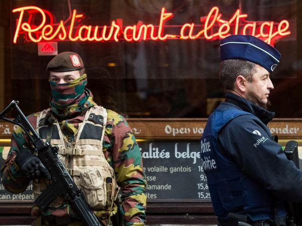 Ein Polizist und Soldaten stehen Wache in der Rue des Bouchers, einer bekannten Ausgehmeile in Brüssel.