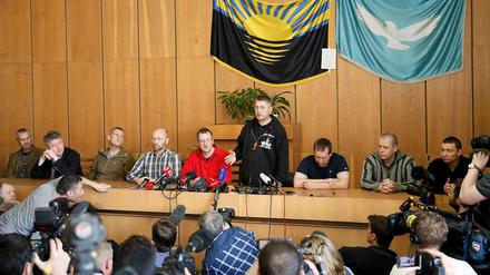 Pressekonferenz mit den festgehaltenen OSZE-Militärbeobachtern: Der selbsternannte Bürgermeister von Slawjansk, Wjatscheslaw Ponomarjow (stehend) führt seine Geiseln den Journalisten vor. 