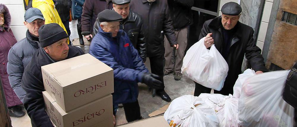 Im ostukrainischen Donezk nehmen Einwohner angelieferte Hilfsgüter in Empfang. 