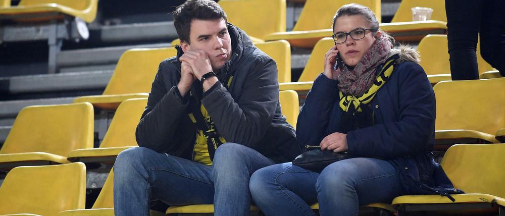 Zwei BVB-Fans sitzen nach der Spielabsage im Stadion.