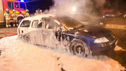 Feuerwehrleute löschen am Rande der Demonstration des fremden- und islamfeindlichen Pegida-Bündnises am 25.01.2016 in Dresden (Sachsen) brennende Autos. 