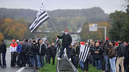 Demonstranten protestieren auf einer Straße in der Bretagne gegen die Ökoabgabe für Lastwagen.