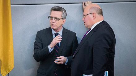 Bundesinnenminister Thomas de Maiziere (links) und Kanzleramtsminister Peter Altmaier (beide CDU) unterhalten sich im Bundestag.