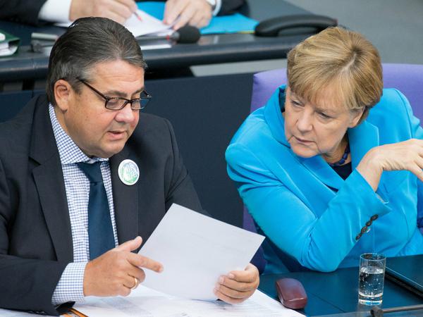 Bundeskanzlerin Angela Merkel (CDU) und Bundeswirtschaftsminister Sigmar Gabriel (SPD) unterhalten sich am 09.09.2015 im Bundestag in Berlin. 