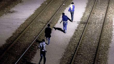 Migranten, die es in Calais über die Absperrungen des Kanaltunnels geschafft haben.