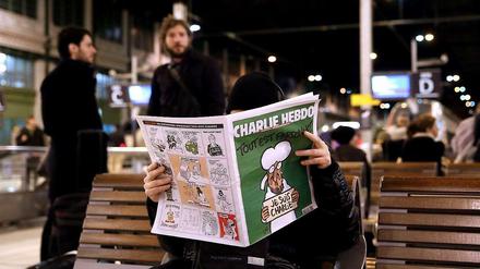 Ein Mann liest am Gare de Lyon in Paris die neueste Ausgabe von "Charlie Hebdo".