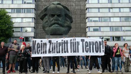 Rechte Demonstranten halten am Montag vor dem Karl-Marx-Monument in Chemnitz ein Plakat hoch. 
