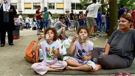 Seifenblasen gegen die Hitze. Hunderte Flüchtlinge warteten in den vergangenen Tagen trotz der hohen Temperaturen vor dem Lageso in Moabit. 