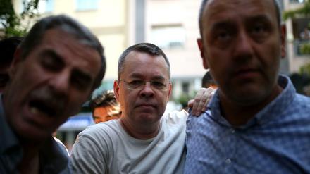 Der amerikanische Pastor Andrew Brunson (Mitte) eskortiert von zwei türkischen Zivilpolizisten am 25. Juli in Izmir. 