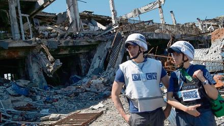 Bezeugen und vermitteln. OSZE-Mitarbeiter am zerstörten Flughafen in Donezk. 