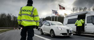 Dänische Polizisten kontrollieren an der dänisch-deutschen Grenze in Krusa Fahrzeuge.