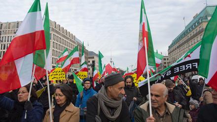 Demonstranten stehen am auf dem Pariser Platz in Berlin und protestieren gegen das iranische Regierungssystem. 