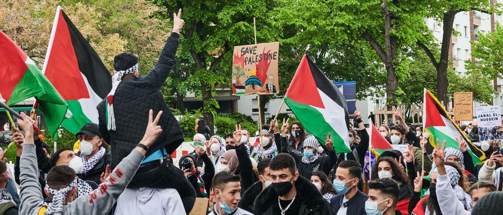 Demonstranten in Berlin halten palästinensische Fahnen hoch, während sie "Free Free Palestine" rufen.