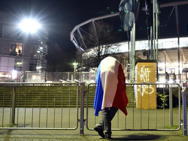 Ein Fan steht am Dienstagabend vor der HDI-Arena in Hannover, in der mit dem abgesagten Fußball-Freundschaftsspiel zwischen Deutschland und den Niederlanden auch der französischen Terroropfer gedacht werden sollte. 