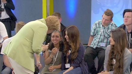 Angela Merkel spricht mit der weinenden Reem, die den Schulbesuch der Kanzlerin in Rostock nutzte, um auf ihr Schicksal aufmerksam zu machen.