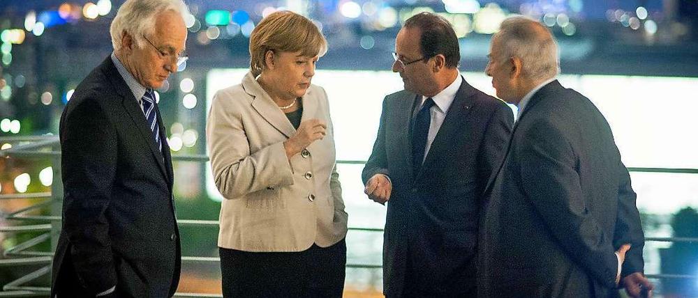 Bundeskanzlerin Merkel und Frankreichs Präsident Hollande mit ihren Dolmetschern.