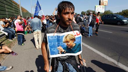 Ein Bild aus vergangenen Zeiten. In Budapest hat sich ein Flüchtling ein Bild von Merkel um den Hals gebunden. 