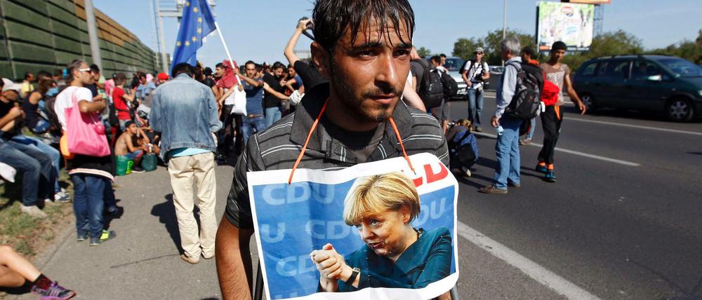 Ein Bild aus vergangenen Zeiten. In Budapest hat sich ein Flüchtling ein Bild von Merkel um den Hals gebunden. 