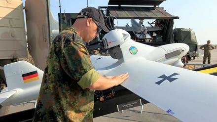 Ein Soldat der Bundeswehr steht neben einer Drohne vom Typ "Luna". 