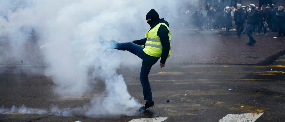 Ein Demonstrant wirft einen Tränengasbehälter während einer Demonstration der "Gelbwesten" weg. Genau ein Jahr nach Beginn der Proteste gibt es in Frankreich neue Demonstrationen.
