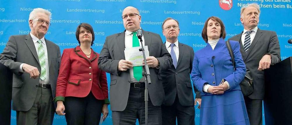 Erschöpft, aber doch erleichtert, haben Bundesumweltminister Peter Altmaier (CDU) in der Mitte des Bildes, die Ministerpräsidenten von Baden-Württemberg, Winfried Kretschmann (Grüne) ganz links im Bild, und von Niedersachsen, Stefan Weil (SPD), neben Altmaier im April den Endlagerkompromiss verkündet. Ganz rechts im Bild ist der grüne Fraktionsvorsitzende Jürgen Trittin zu sehen, neben ihm steht die FDP-Berichterstatterin Angelika Brunkhorst. Zwischen Kretschmann und Altmaier steht die Unions-Berichterstatterin Maria Flachsbarth (CDU). 
