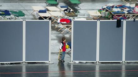 Ein Flüchtlingsjunge steht in München in der Erstaufnahmeeinrichtung für Flüchtlinge in einer Messehalle. 