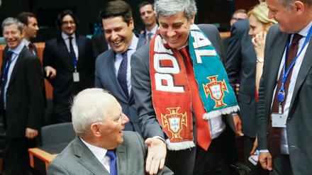 Portugals Finanzminister Mario Centeno mit EM-Siegerschleife begrüßt Wolfgang Schäuble beim Treffen der Euro-Finanzminister.