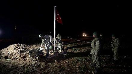 Soldaten stellen eine türkische Flagge auf dem neuen Grab von Suleyman Shah auf.