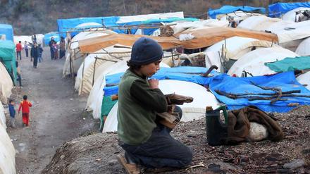Ärmliche Bedingungen: Ein syrisches Kind in einem türkischen Flüchtlingslager sammelt Holz, um die behelfsmäßigen Unterkünfte zu heizen.