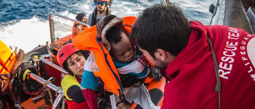 Ein Baby wird in ein Rettungsboot gebracht. 