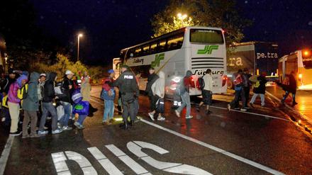 Flüchtlinge kommen mit Bussen aus Ungarn über Österreich in der Nacht zum 06.09.2015 an der Autobahn-Raststätte Aichen bei Ulm (Baden-Württemberg) an. Die Überschreitung der zulässigen Lenkzeiten der Busfahrer zwang hier zu einem unfreiwilligen Zwischenstopp auf dem Weg nach Stuttgart, bei dem die Menschen von Hilfsorganisationen betreut und versorgt wurden. 