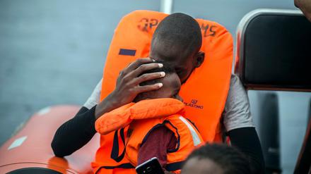 Ein Mann hält seinen Sohn im Arm, nachdem er von Helfern von seinem Schlauchboot im Mittelmeer gerettet wurde. 