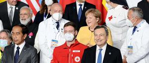 Kanzlerin Angela Merkel zwischen zwei Ärzten auf einem Foto beim G20-Gipfel.