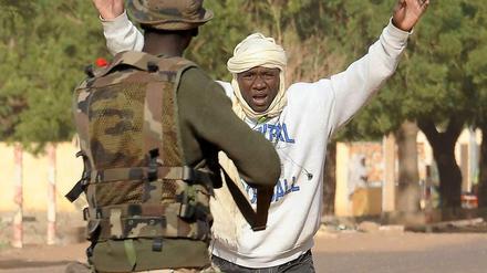 Ein malischer Soldat nimmt an einem Kontrollpunkt in der nordmalischen Stadt Mali einen Mann fest. In Gao war es nach zwei Selbstmordanschlägen zu heftigen Kämpfen gekommen. Die malischen Soldaten gehen nach Angaben der französischen Armee von Haus zu Haus, um Islamisten zu finden. 