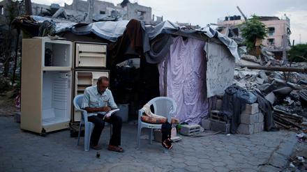 Ein Palästinenser sitzt im Gazastreifen vor den Überresten seines Hauses.