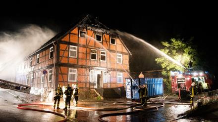 Feuerwehrleute löschen am späten Sonntagabend in Boizenburg an der Elbe (Mecklenburg-Vorpommern) eine brennende geplante Notunterkunft für Flüchtlinge. 