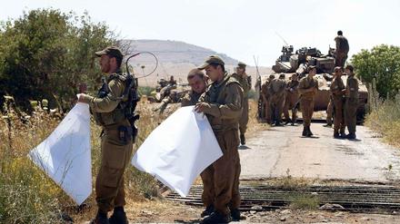 Israelische Soldaten mit Landkarten beobachten die Grenze zu Syrien.