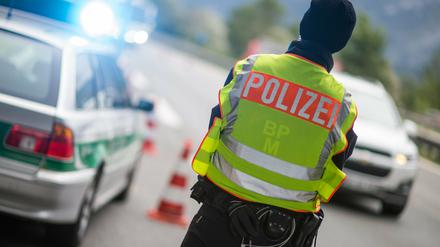 Ein Polizeibeamter beobachtet an der Anschlussstelle Bad Reichenhall der Autobahn A8 von Salzburg nach München Fahrzeuge, die aus Österreich kommen. 