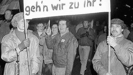 Leipzig, im Februar 1990. Teilnehmer einer Montagsdemonstration machen auf einem Plakat deutlich, wie sie sich die Zukunft vorstellen. 